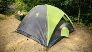 How to Start Tent Camping: A Beginner's Guide (+ Tents We Actually Own) 3 3 person Coleman Galileo Camping Tent at a campsite beside a green canoe and river