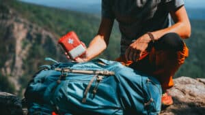 Best Emergency Antibiotic Kit: What to Include & How to Get One 11 hiker pulling out an Emergency Antibiotic Kit from his pack on a mountain peak