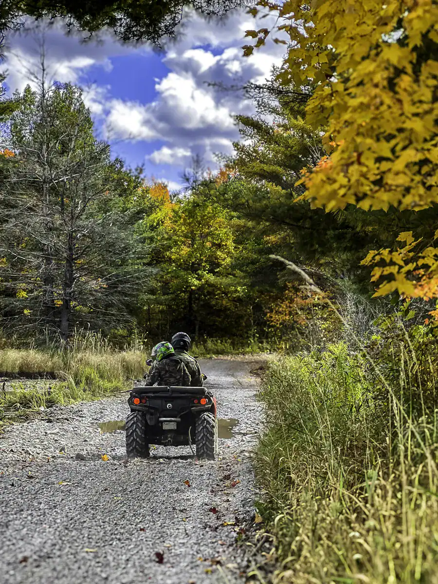 Father and son riding an atv on the Nephton Trails during autumn
