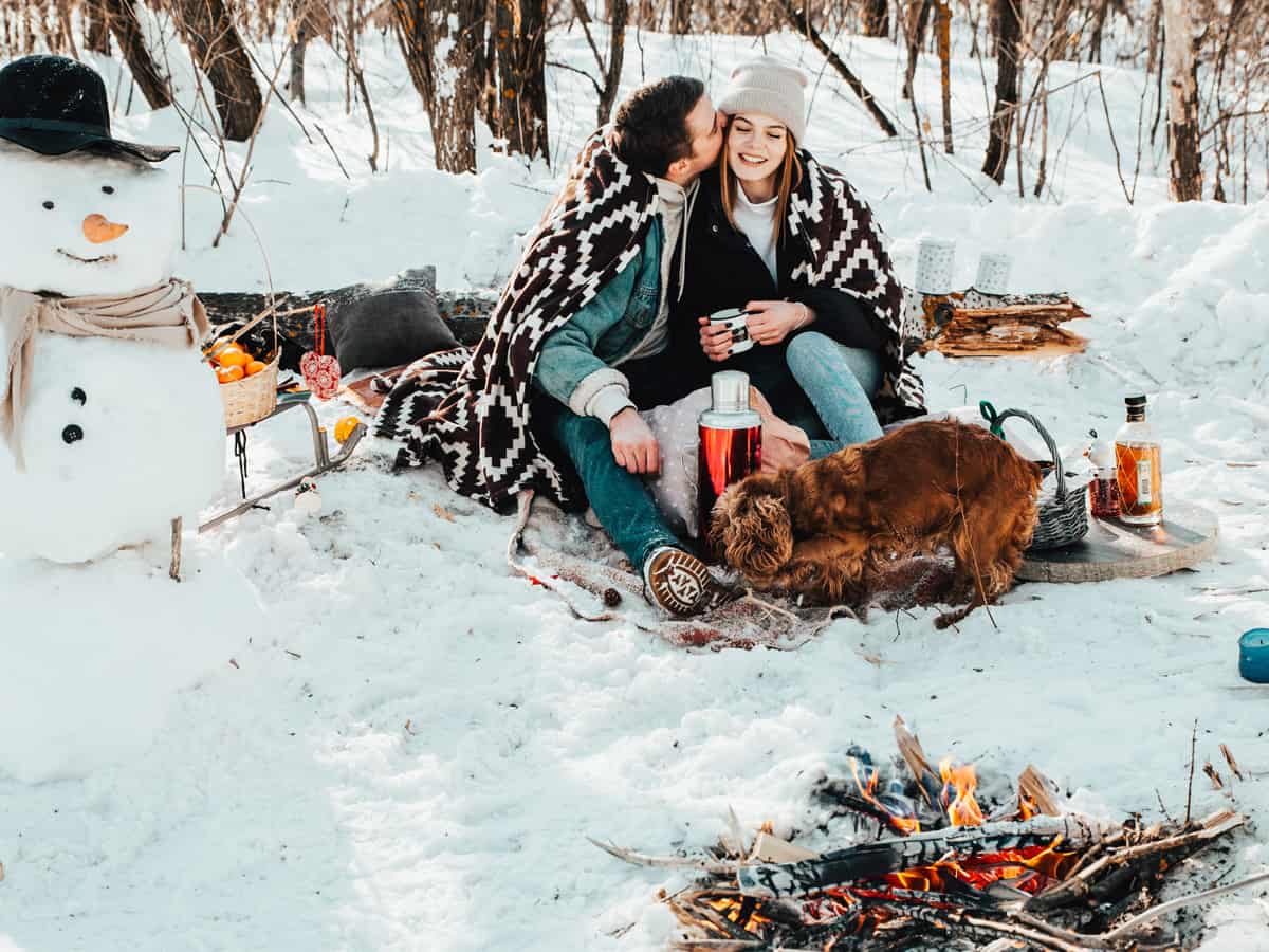 Outdoor Date Idea - Campfire - Beautiful couple in love on a winter picnic