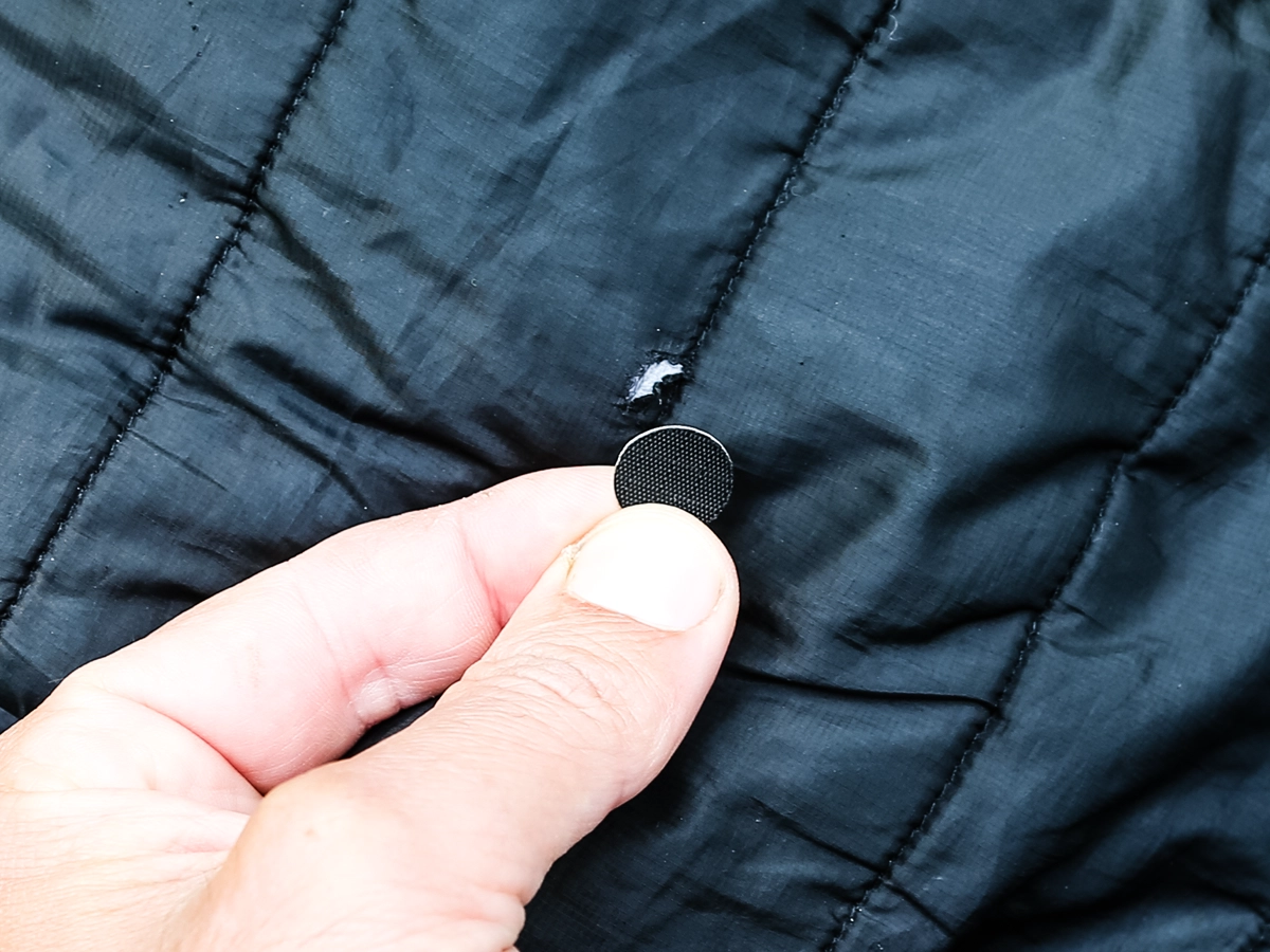 Using an aZengear repair patch to cover a tear in a puffer coat 