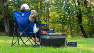 Camper sitting by the campfire with the BougeRv 12-volt fridge