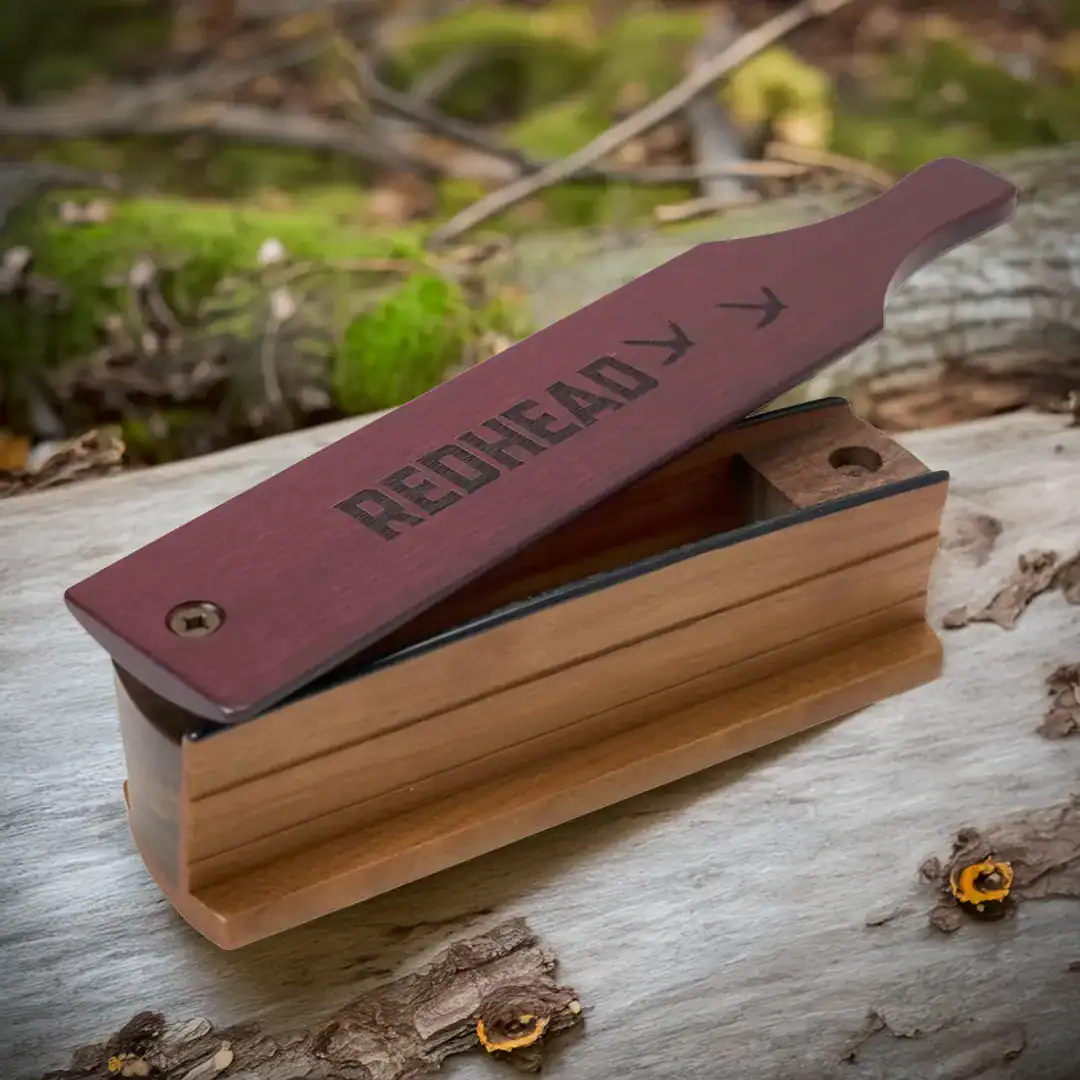 cedar, cherry Redhead turkey box call on a log in the forest
