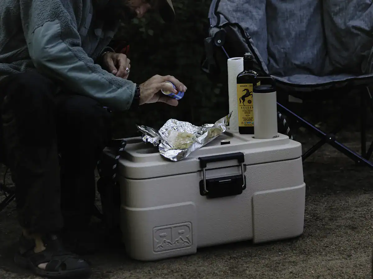 Camper using the Rugged Road 45 cooler lid for meal prep