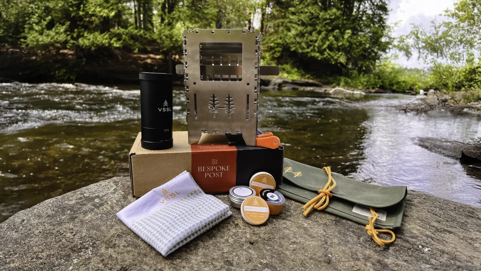 Contents of the Bespoke Post Subscription Box - Outdoors Edition laid out on a rock