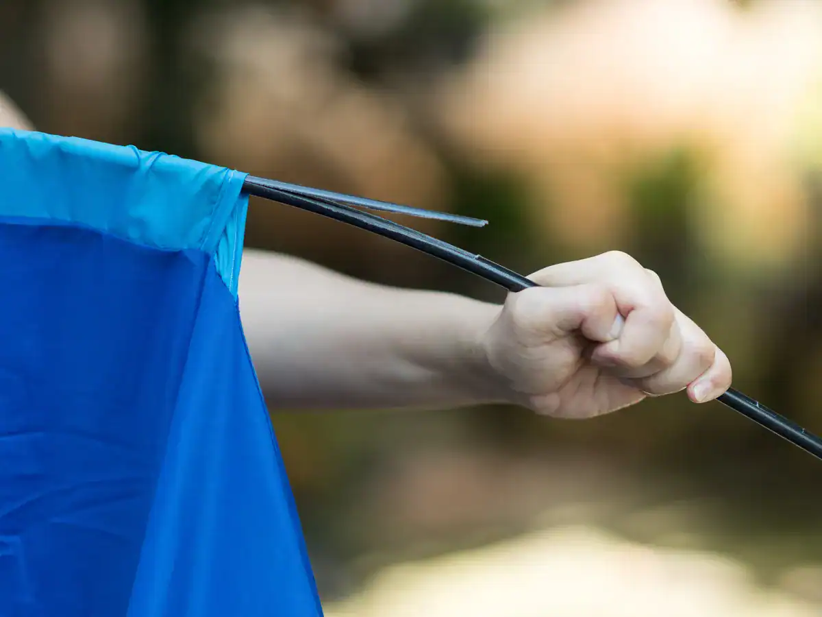 Camper holding a snapped tent pole during tent assembly