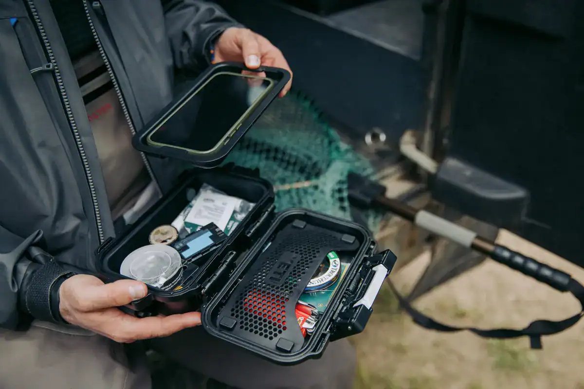 Angler organizing his YETI LoadOut GearBox 1 with fishing accessories