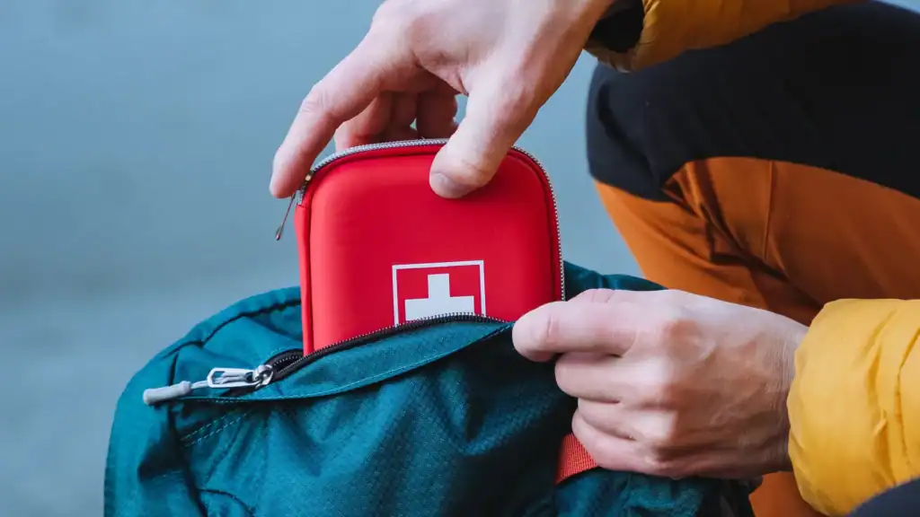 hiker pulling out a first aid kit for emergencies