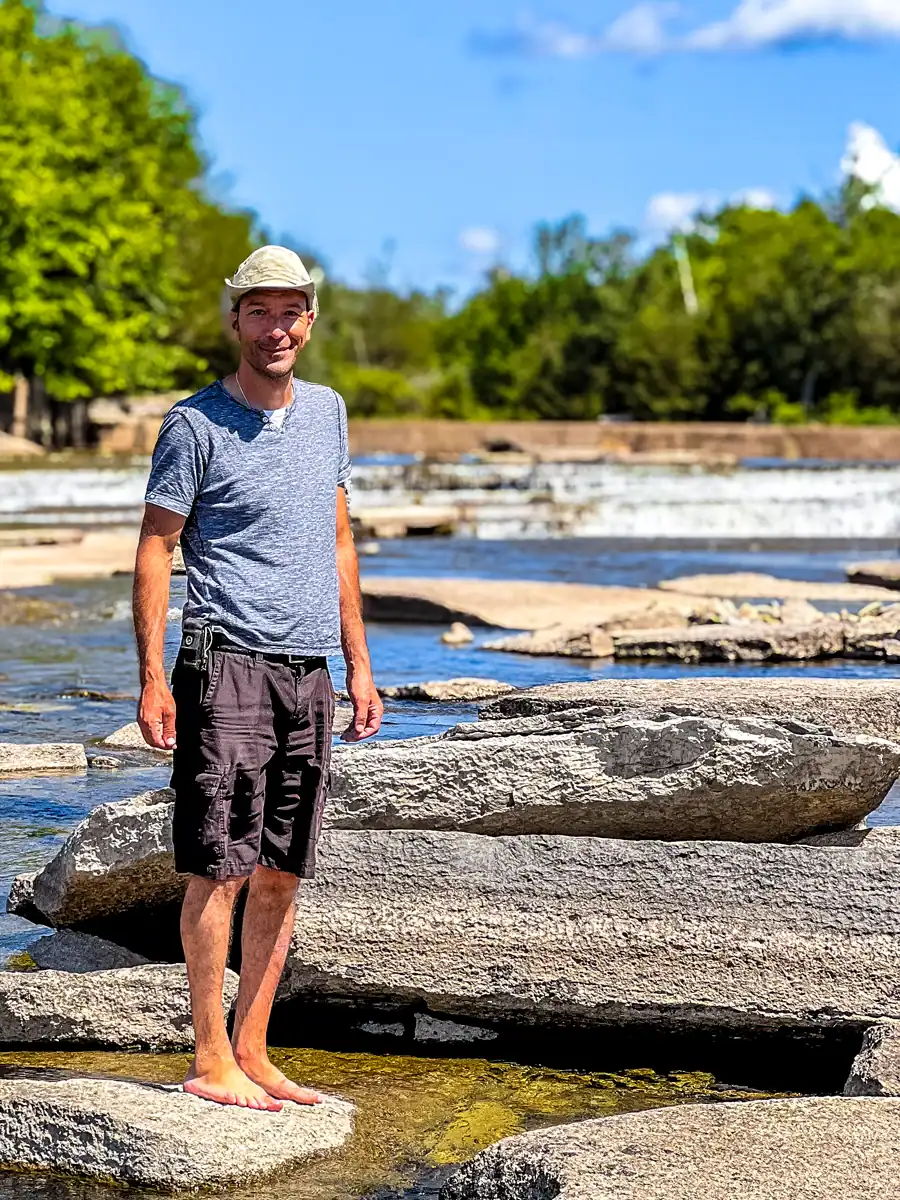Crowe Bridge Park: A Hidden Swimming Spot & Natural Waterfall Near Campbellford 1 Stelios standing on a rock in the Crowe River at the Crowe Bridge Park
