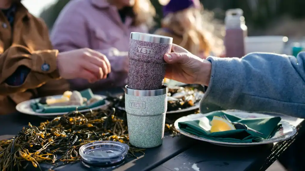 eating an outdoor meal while holding the red riverhead collection stackable cup