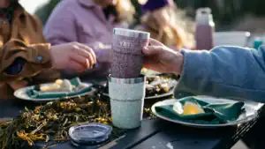 eating an outdoor meal while holding the red riverhead collection stackable cup
