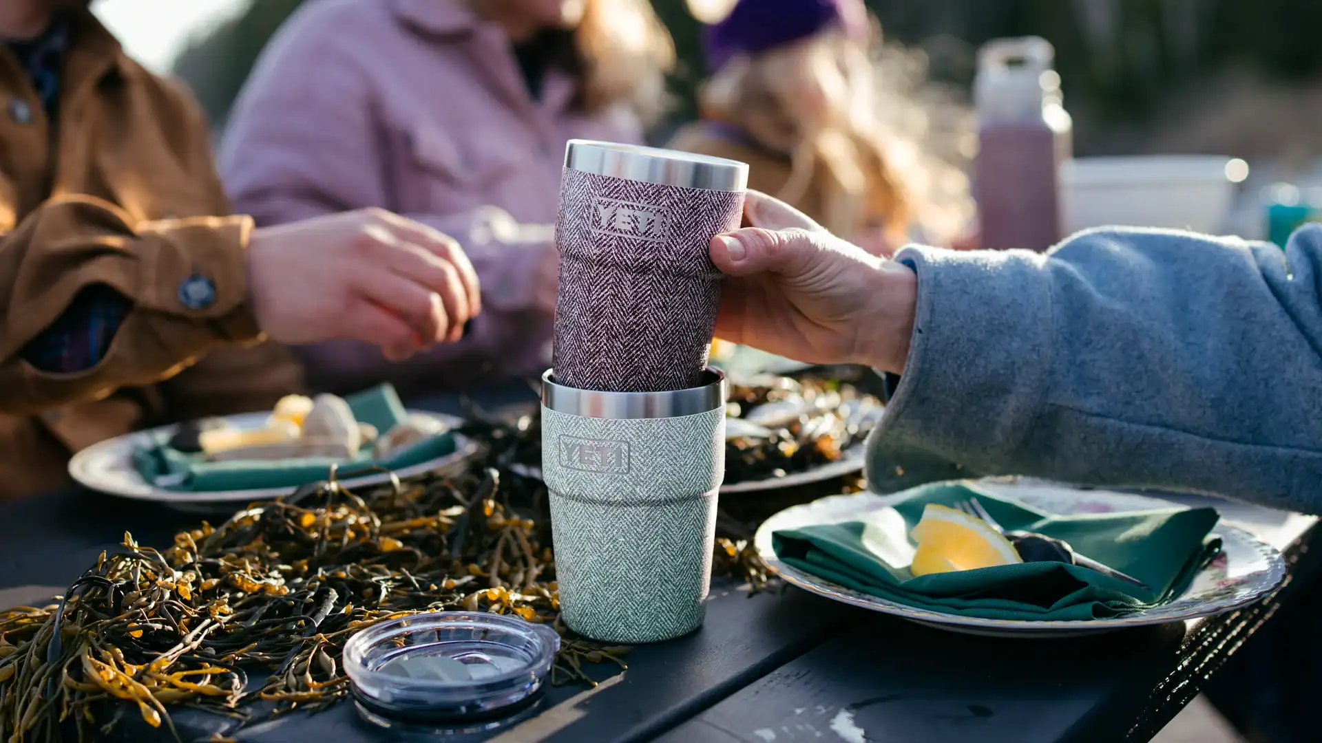 eating an outdoor meal while holding the red riverhead collection stackable cup